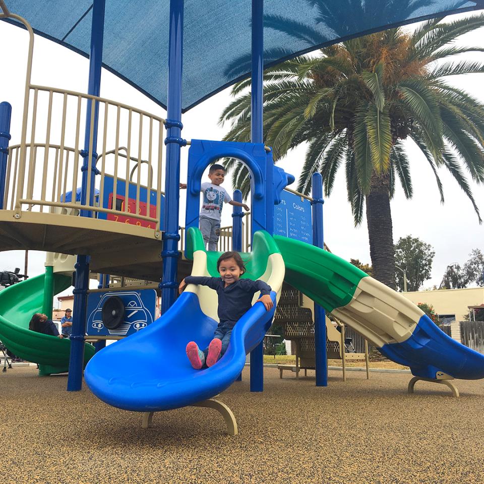 Child going down a slide at the park